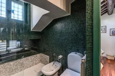 a bathroom with green tiled walls and a sink at Domus in Via Del Corso in Rome