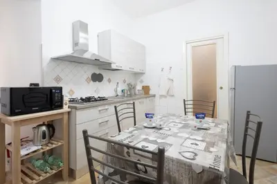 a kitchen with a table with chairs and a refrigerator at La Casa Di Alice in Rome