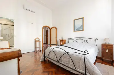 a white bedroom with a bed and a wooden floor at Rome Historic Center Stylehouse in Rome