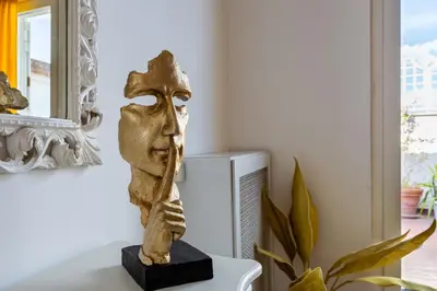 a statue of a head sitting on a table next to a plant at Saint Peter's Luxury Terrace Suites in Rome