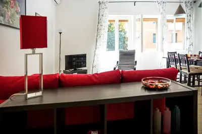 a red couch in a living room with a table at La Casa Di Mamma in Rome