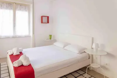 a white bedroom with a bed with towels on it at La Casa Di Mamma in Rome