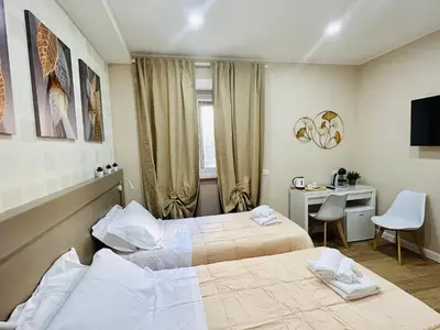 a hotel room with two beds and a desk and a computer at Segesta Rooms in Rome