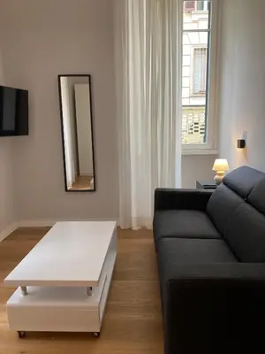 a living room with a black couch and a white coffee table at Nizza 33 in Rome