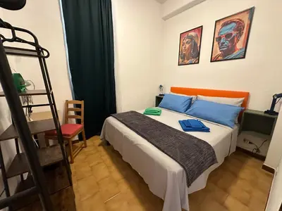 a bedroom with a bed with blue pillows and a ladder at ROMA Appia in Rome