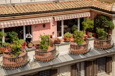 a building with a bunch of potted plants on it at The Inn at the Spanish Steps Luxury Collection - The View in Rome