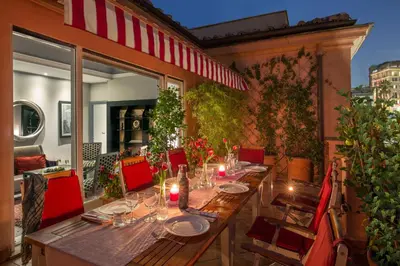 a long wooden table with candles on a patio at The Inn at the Spanish Steps Luxury Collection - The View in Rome