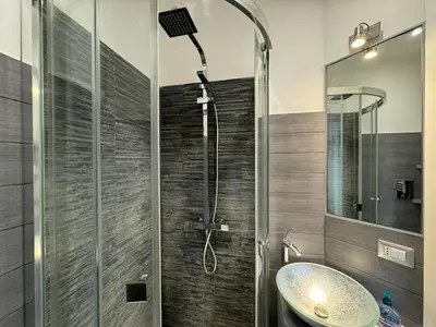 a bathroom with a shower with a sink and a mirror at G&G Apartment in Rome Quadraro in Rome