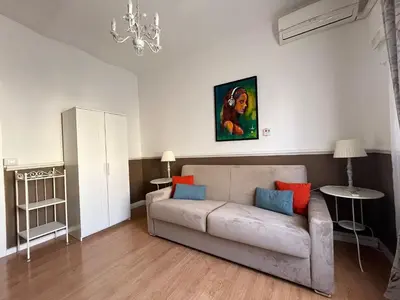 a living room with a couch and a painting on the wall at Veniero Apartment in Rome