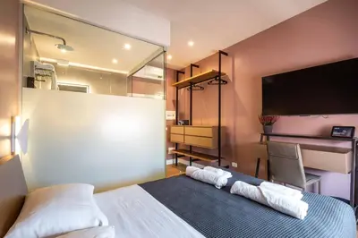 a bedroom with a bed and a desk and a tv at LUMINA3 Luxury Room ROME in Rome