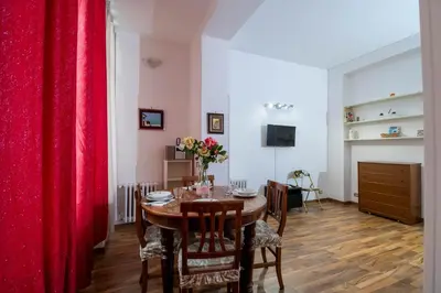 a dining room with a table and red curtains at House Serena in Rome