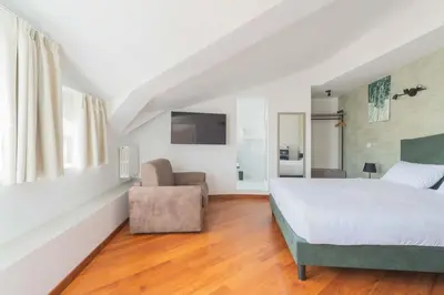 a bedroom with a large bed and a chair at Adelante Rooms San Giovanni in Rome