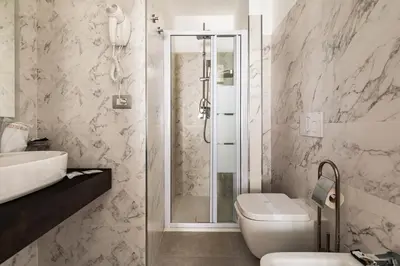 a bathroom with a shower and a toilet and a sink at Adelante Rooms San Giovanni in Rome