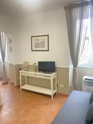 a living room with a white desk with a television at Sweet home Trastevere 2- Roma in Rome