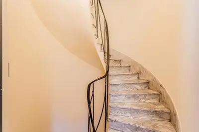 a spiral staircase with a metal rail at Sweet home Trastevere 2- Roma in Rome