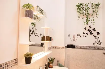 a bathroom with a mirror and plants on the wall at Stefy's House in Rome