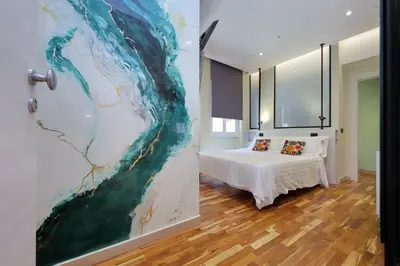 a bedroom with a bed and a painting on the wall at San Pietro Luxury Rooms in Rome