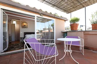 a patio with purple chairs and a table on a balcony at Spagna Prestige Apartment in Rome