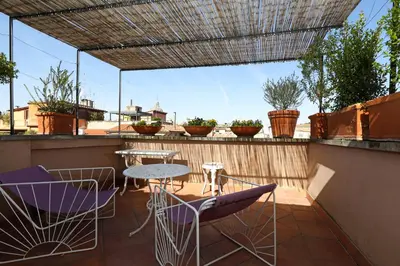 a patio with a table and chairs on a roof at Spagna Prestige Apartment in Rome