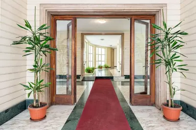 a red carpet in a hallway with two potted plants at Vatican Penthouse 1 by Almond Tree in Rome