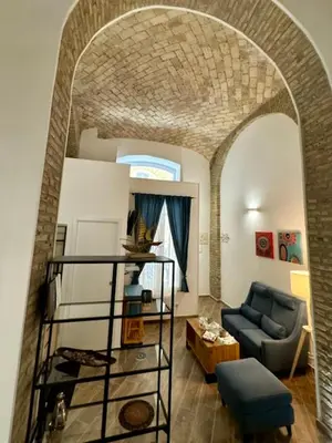 a living room with an archway and a blue couch at Casa Valenziani in Rome