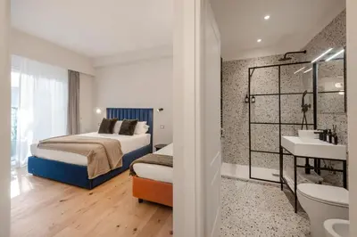 a bedroom with two beds and a bathroom with a sink at The Rubens Collection in Rome
