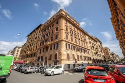 a large building with cars parked in front of it at Properzio 37 in Rome