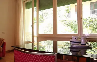 a dining room with a table and a large window at Pràti Home in Rome