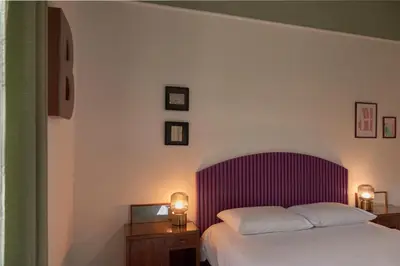 a bedroom with a bed with a purple headboard at Bivio - Casa Verde in Rome