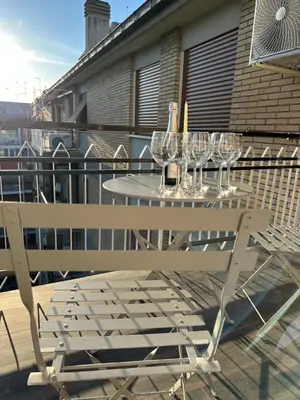 a white table and chairs on a balcony with wine glasses at Domus Paolina Ostiense in Rome