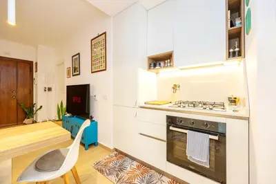 a kitchen with white cabinets and a stove top oven at Luminosa camera con bagno privato interno - vicina alla metro in Rome