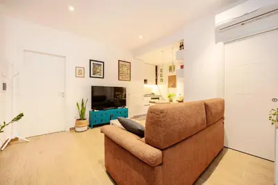 a living room with a couch and a television at Luminosa camera con bagno privato interno - vicina alla metro in Rome