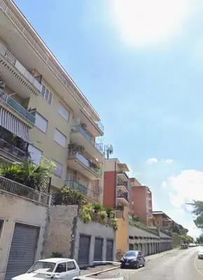 a street with cars parked in front of a building at Bilocale Socrates in Rome