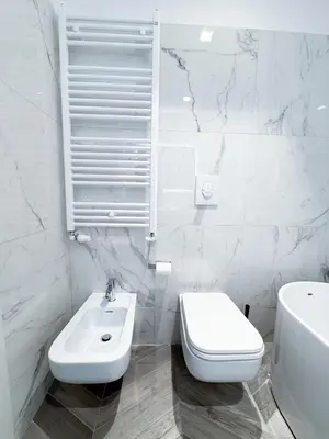 a white bathroom with a toilet and a sink at F House Trastevere in Rome