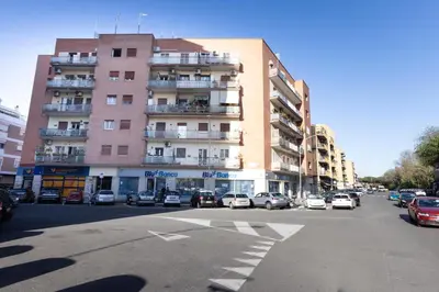 a tall building with cars parked in a parking lot at Marisa lovely house in Rome