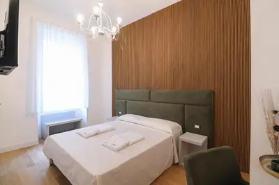 a bedroom with a bed and a chandelier at Re Di Rhome Guest House in Rome
