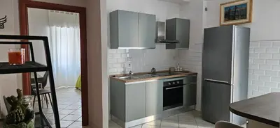 a kitchen with a sink and a refrigerator at Cento House Casa Vacanze Roma in Rome