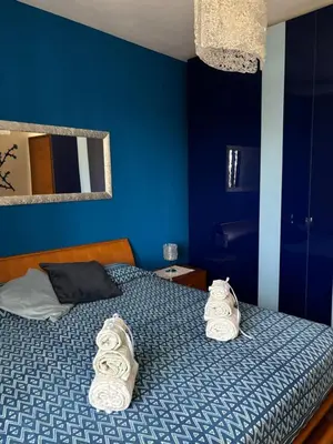 a blue bedroom with a bed with towels on it at GrElly's House - Holiday in Rome - 50 meters from the Metro in Rome