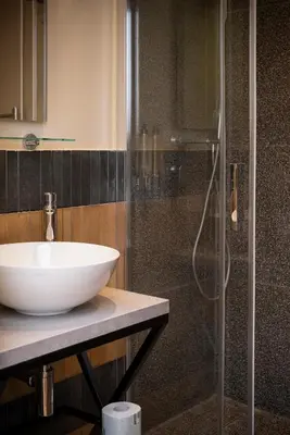 a bathroom with a sink and a glass shower at Residenza Leone XIII in Rome