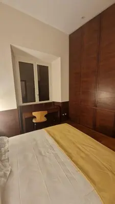 a bedroom with a large bed and wooden cabinets at Luxury Apartment delle Fratte in Rome