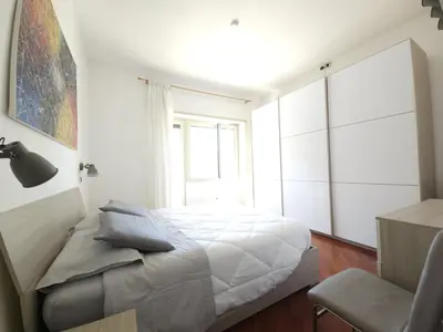 a white bedroom with a bed and a window at Like at Home Gianicolense in Rome