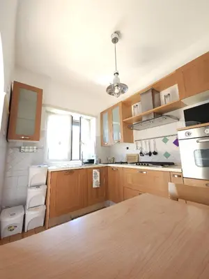 a kitchen with wooden cabinets and white appliances at Like at Home Gianicolense in Rome