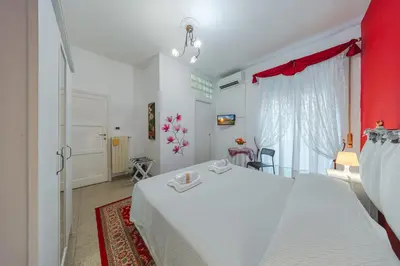 a bedroom with a white bed and a red curtain at B&B Divina Roma in Rome