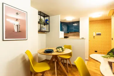 a small dining room with a table and yellow chairs at The Hive - Holiday Home in Trastevere in Rome
