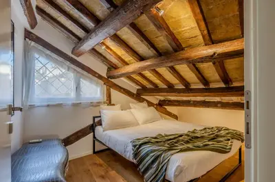 a bedroom with a bed in a room with wooden ceilings at Dimora Capo di Ferro in Rome