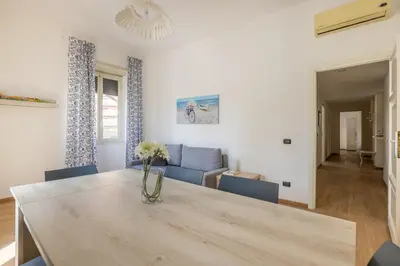 a dining room and living room with a table and chairs at Casa EMMA, casa vacanze Aurelio in Rome