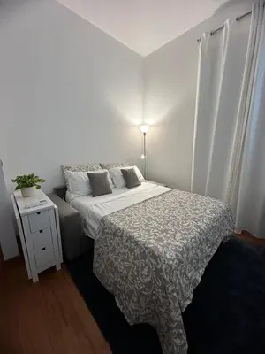 a bedroom with a bed and a table with a lamp at L'Attichetto di via Padova in Rome