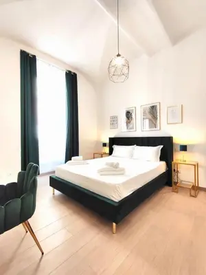 a bedroom with a large bed and a chair at The Gold Apartment in Rome