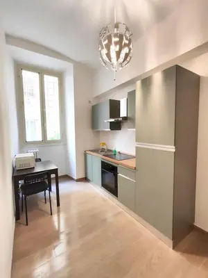 a kitchen with a table and a chandelier at The Gold Apartment in Rome