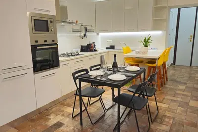 a kitchen with a table and chairs in a kitchen at Cozy Modern Apartment with Terrace - Pantheon in Rome